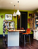 Bunter Stilmix in der Wohnküche mit grünen Wänden