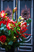 Winterlicher Strauß mit roten Blumen wie Rose und Amaryllis