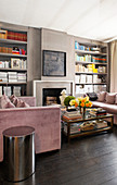 Two sofas opposite one another in front of open fireplace flanked by bookshelves
