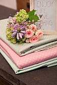 Bouquet on stacked folded fabrics in pink and mint green