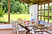 Set table on roofed terrace in summery garden