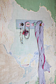 Garderobe aus Garnrollen an der Wand mit abblätternder Farbe
