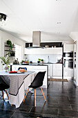 Counter and dining area on black floor tiles in fitted kitchen