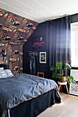 Car-patterned wallpaper and bed in teenager's beroom