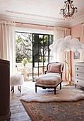 Antique, French day bed and floor lamp with ostrich feathers in front of a balcony door