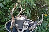 Candle lantern made from wax remnants decorated with twigs