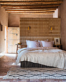Bett an der Raumteilerwand im marokkanischen Schlafzimmer