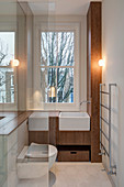 Small narrow bathroom with wooden fittings and toilet