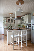Breakfast bar and bar stools in white kitchen
