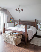Selbst gebautes Holzbett, Nachtkästchen und Korbtruhe im Schlafzimmer