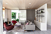 Loungebereich mit Designer-Sitzmöbeln und Raumteilerregal