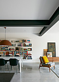 Dining table in front of bookshelves in modern interior