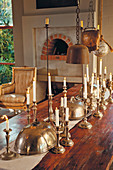 Silver candlesticks and silver plate covers on wooden table