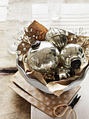 Vintage silver Christmas-tree baubles in ceramic bowl