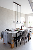 Set table in dining room in wintry shades with grey wall