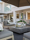 Concrete-effect coffee table and upholstered furniture on terrace
