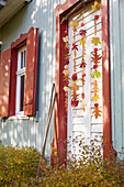 DIY-Mobile aus buntem Herbstlaub und Lampionblumen