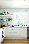 White-painted wooden walls and ceiling in country-house kitchen
