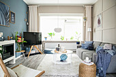 Wohnzimmer im skandinavischen Stil mit Wänden in Blau und Beige