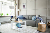 Grey sofa against beige panelled wall in bright living room