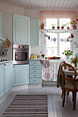 Cosy kitchen-dining room with pale blue country-house-style cabinets
