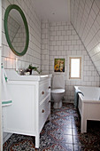 Patterned floor tiles in small bathroom with sloping ceiling