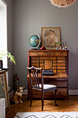 Antique bureau and vintage-style accessories against grey wall