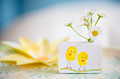Chicks drawn on box holding flowers decorating table