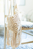 Macrame bag hung from chair backrest