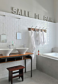 Decorative lettering in French on wall of grey-and-white bathroom