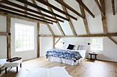 Exposed roof structure and beams in large bedroom