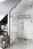 Shower and shelving in niche below sloping ceiling