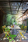 Colourful garden chairs around metal table on Mediterranean terrace