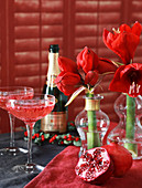 Champagne saucers, pomegranate and amaryllis on set table