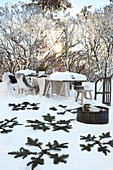 Pine branches in snow with set table in background