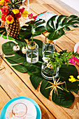 Bouquet of flowers in pineapple vase and leaves in glass vases on table decorated for Christmas
