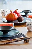 Table set in Oriental style with Hokkaido pumpkins on plate
