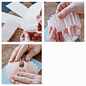 Hands folding a rosette of pink paper