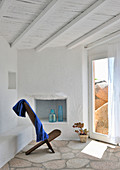 Chair on stone floor next to French window