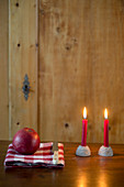 Two lit red candles in cake-shaped candle holders