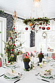 Festively set dining table below Christmas wreath