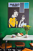 Pop-Art-Bild an grüner Wand über dem Esstisch