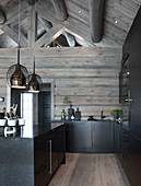 Black kitchen in log cabin with exposed roof structure
