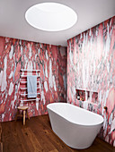 Freestanding bathtub and towel dryer in the bathroom with wallpaper in red marble effect