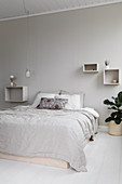 Double bed, shelves and pendant lamps in bright bedroom