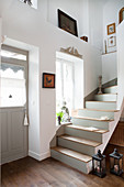 Staircase with grey risers next to front door in country house