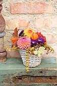 Arrangement of brightly coloured autumn flowers in basket