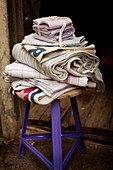 Folded home textiles on wooden stool