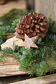 Pine cone and wooden star on conifer branches