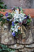 Cross planted with silver ragweed, heather and violas decorating grave
